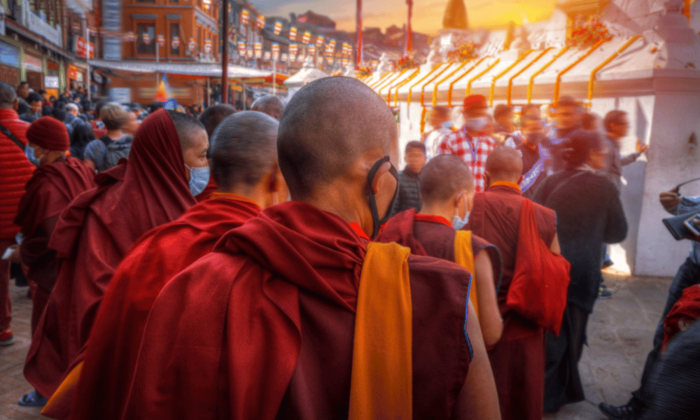 monks in buddhanath stupa during sunset